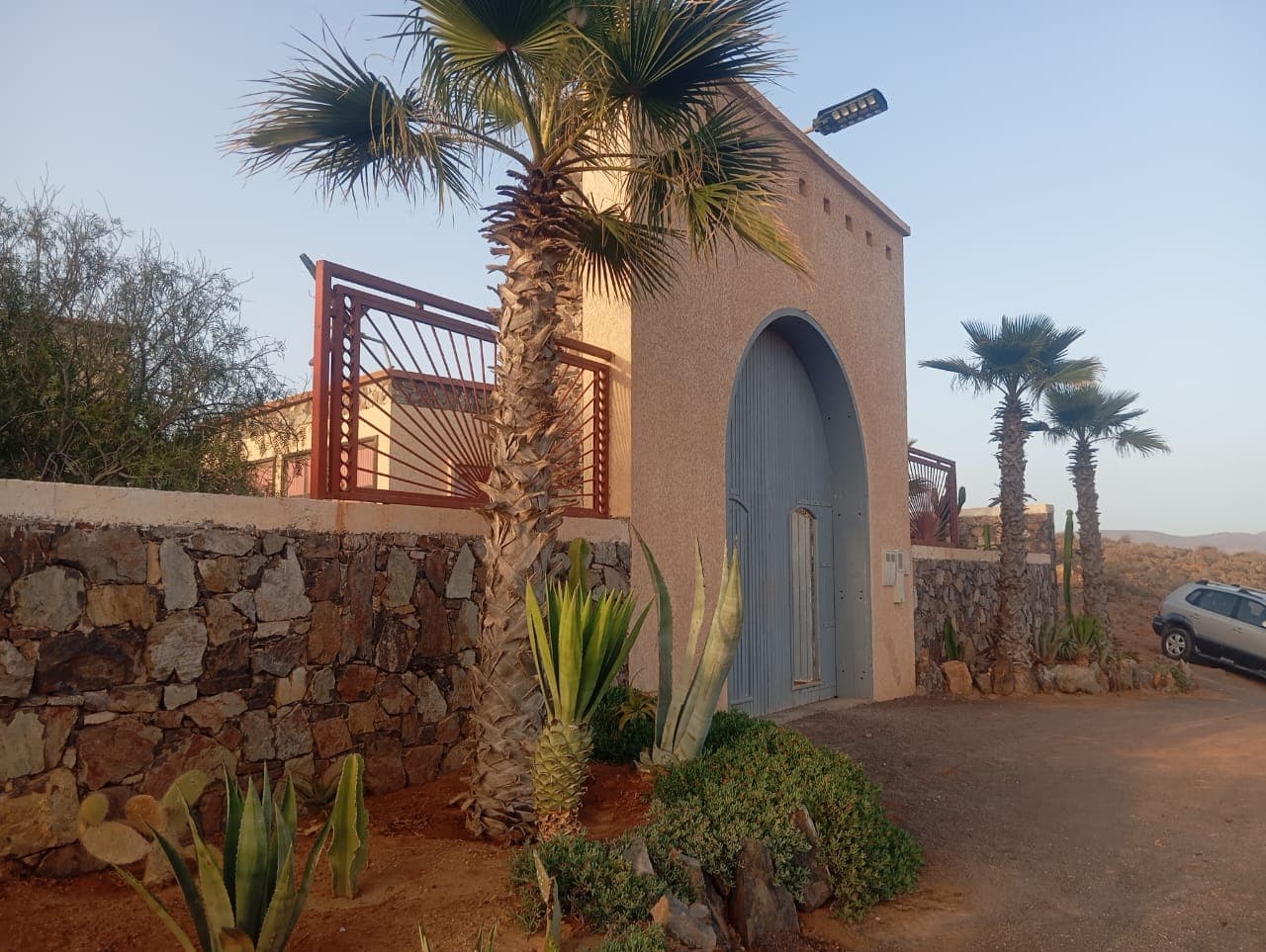 Hotel entrance with distinctive arched doorway and palm trees