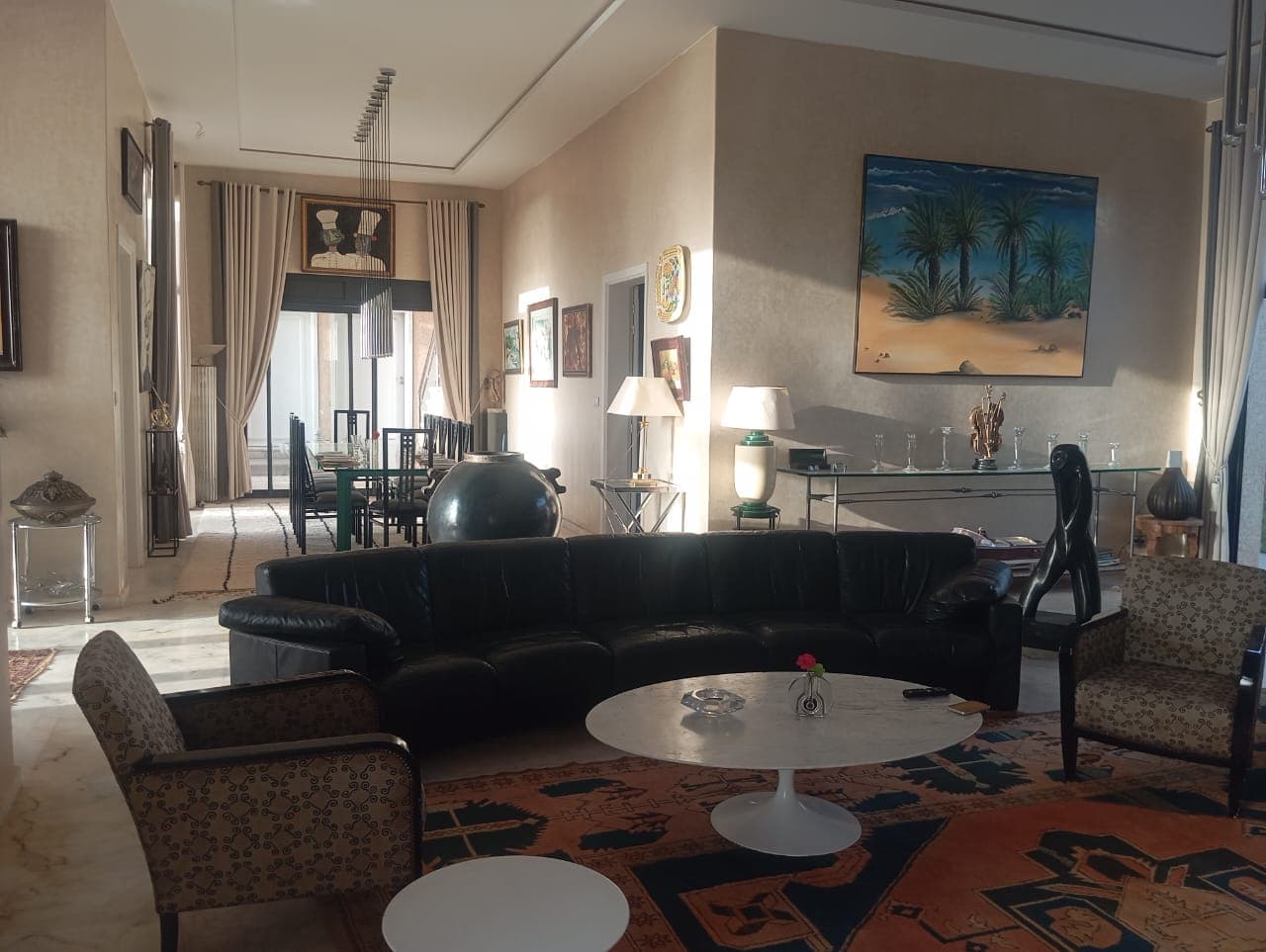 Elegant hotel living room with black leather sofa and artwork