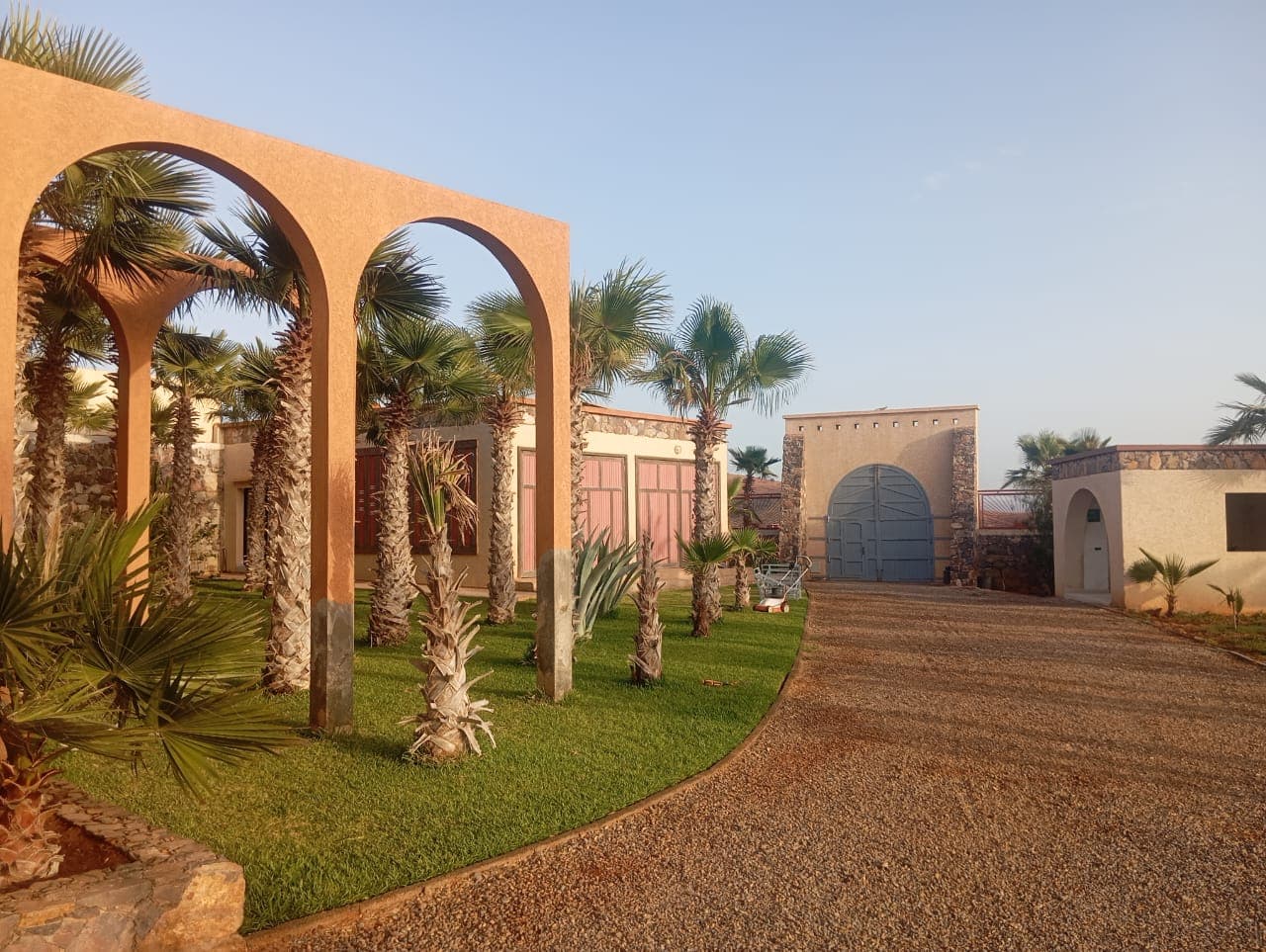 Traditional Moroccan arches with landscaped gardens and palm trees