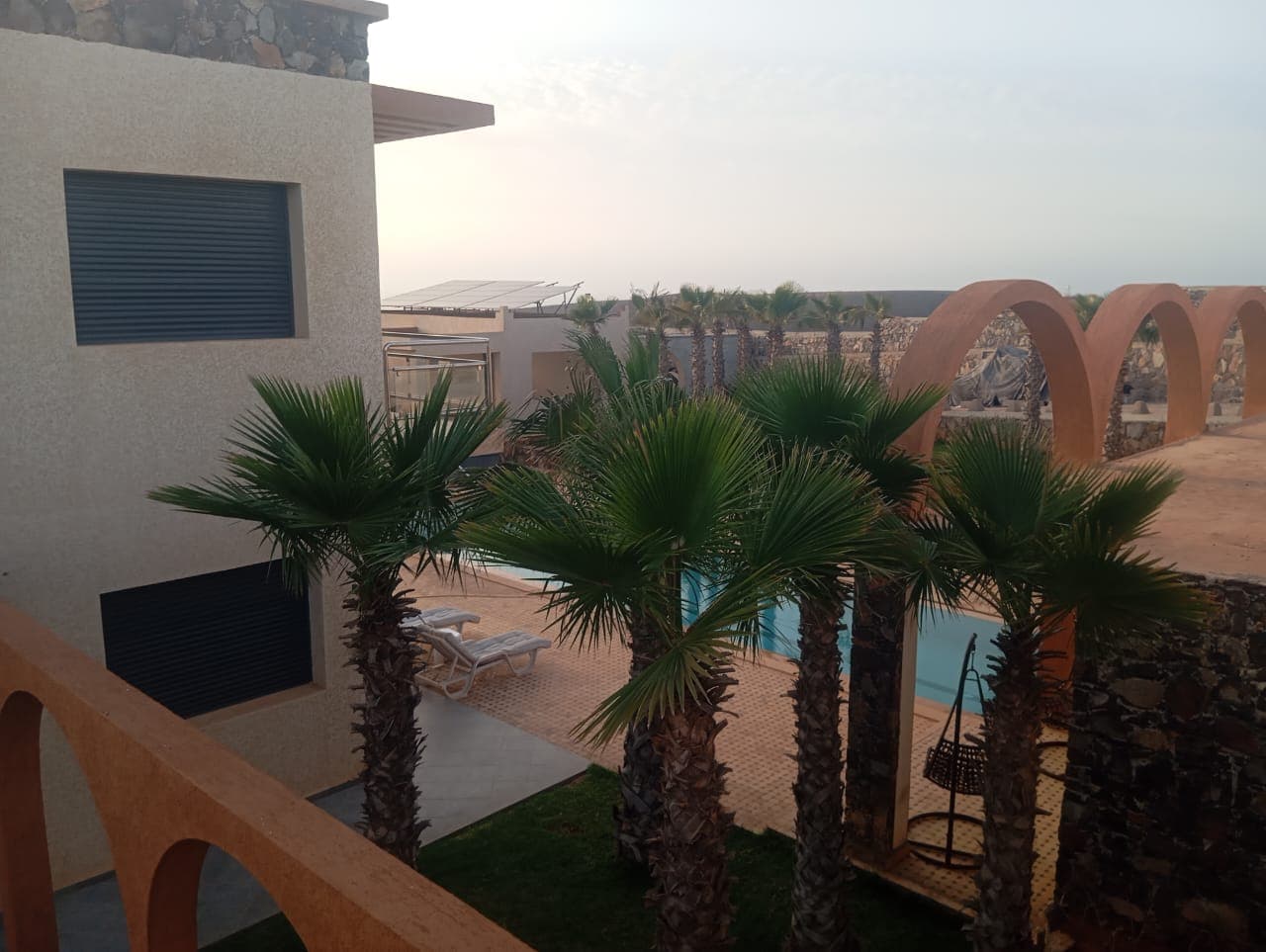 Upper level terrace overlooking pool with Moroccan arches
