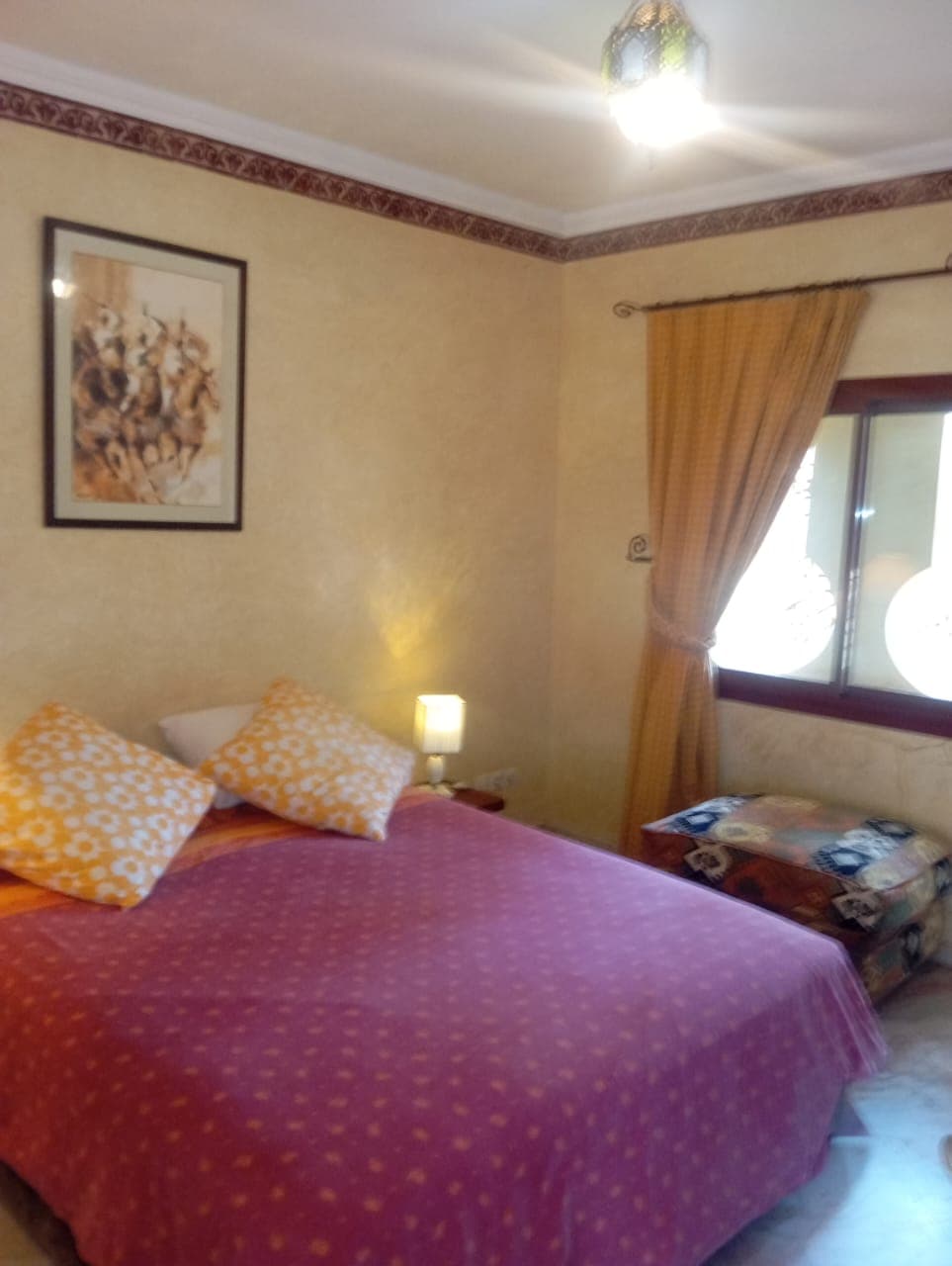 Cozy villa bedroom with purple bedding and traditional decor