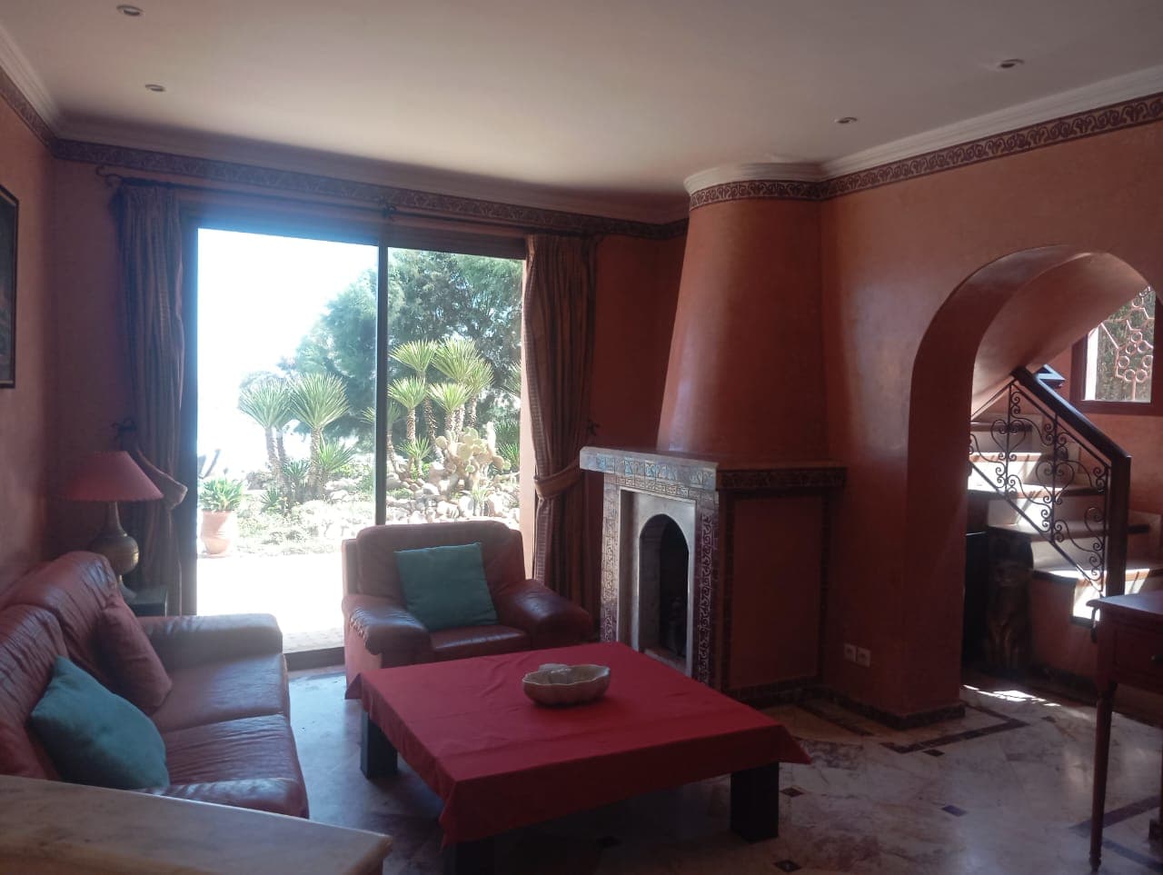 Villa living room with traditional fireplace and garden views